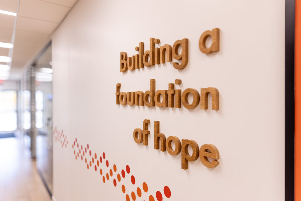 A sign on the wall of a hall at the Hearth that reads "Building a foundation of hope."
